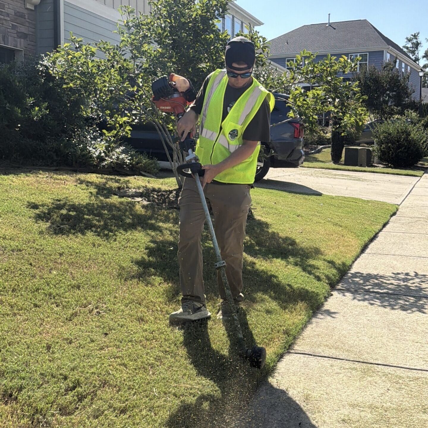 Mark edging the sidewalk during lawn mowing service