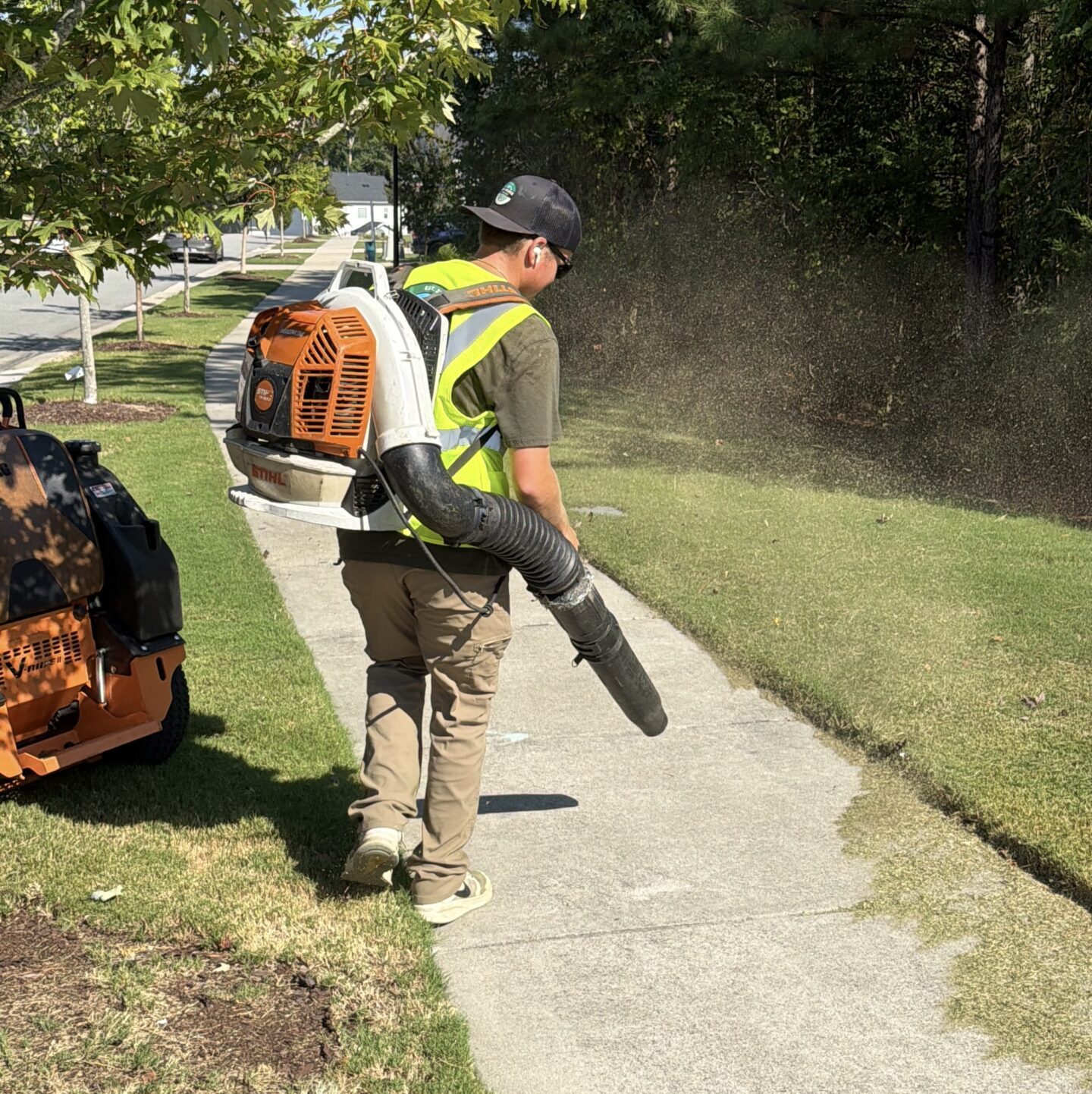 Mark blowing off a property after the mowing, string trimming, and edging is done